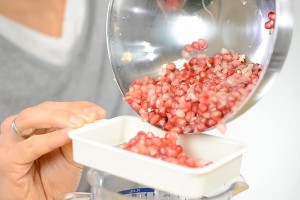 Putting the pomegranate seeds through a strainer